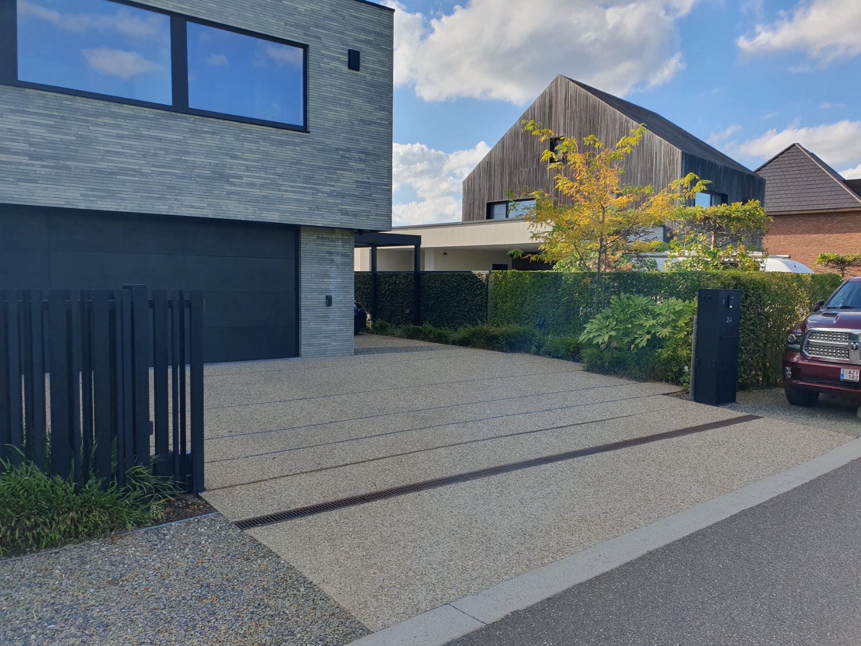 Overzicht van de oprit in licht uitgewassen beton bij een moderne woning